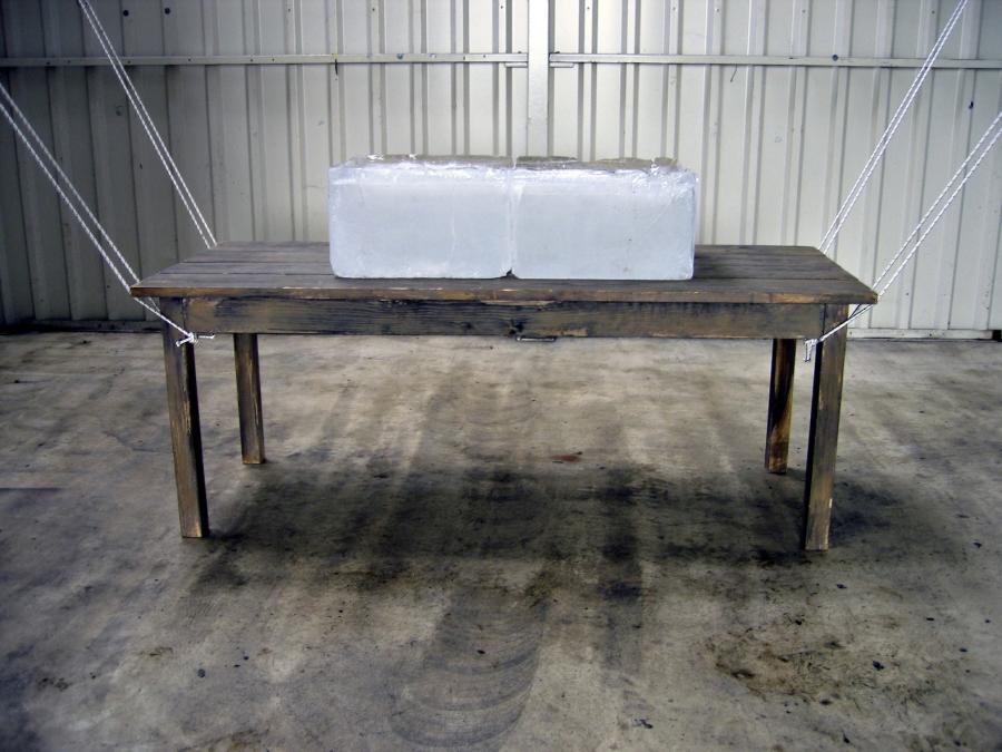 Carla Guagliardi Opera, 2004 Installation Table of wood (2,20m x 1,00m), elastic ropes and a block of ice with 150 kg.  Variable dimension